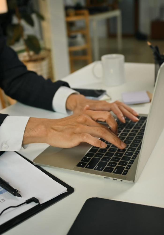 Businessman hands typing on laptop keyboard, checking financial